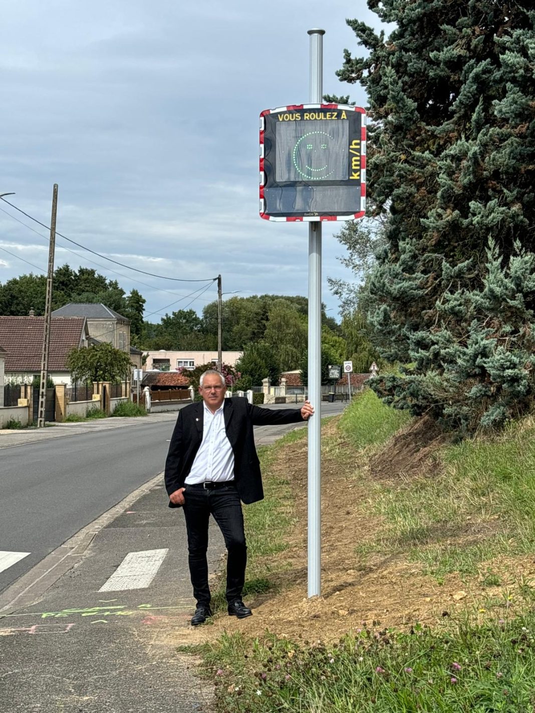 Renaud Bourgeois, maire de Cuise-la-Motte, devant un radar pédagogique EVOLIS Vision installé sur une route communale.